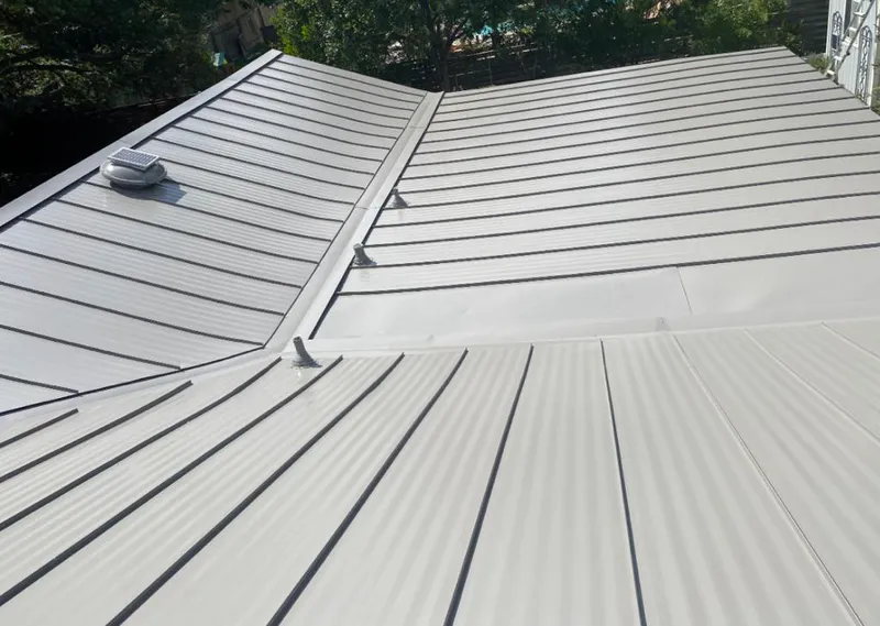 Solar attic fan installed on a metal roof for Roof Ventilation in Benner